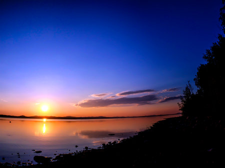 panorama of a picturesque multicolored golden sunset over a calm lake, summer, Lake Uvildy, southern...