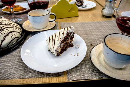 piece of birthday cake on a white plate on the table among the dishes