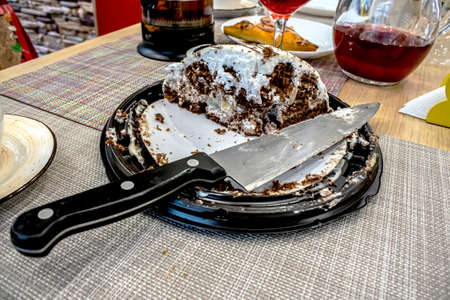 remaining piece of cake on a platter, a knife, dishes after the end of the party