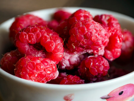 fresh bright frozen raspberries in a cup on the table, macroの写真素材