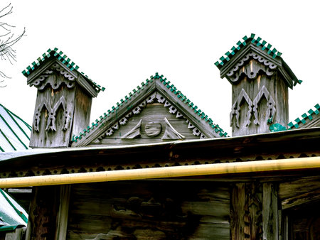 wooden decorations over the gate to a typical old wooden house on the street of a small Ural city at the beginning of winterの写真素材