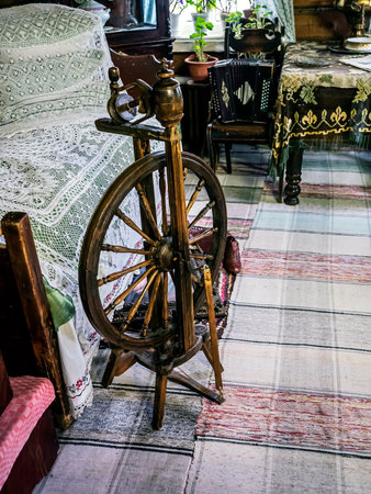 an old wooden spinning wheel in the upper room of a rustic old house, an old traditional village lifeの写真素材