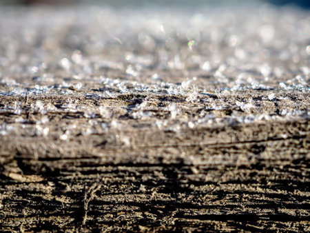 ice crystals on a wooden board illuminated by the morning sun, macro, narrow focus areaの写真素材