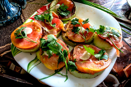 Fried zucchini slices with crispy crust, tomatoes, herbs and garlicの写真素材