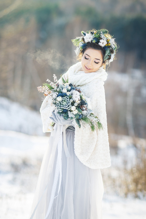 Cute bride with a bouquet. Winter wedding bouquet.の写真素材
