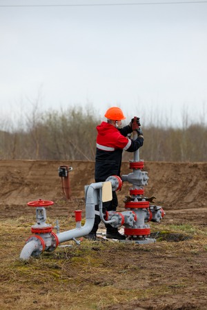 Oilman specialist in overalls serving the oil well and check the oil pump Russiaのeditorial素材