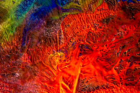 a thin piece of ice and spilled multicolored paint