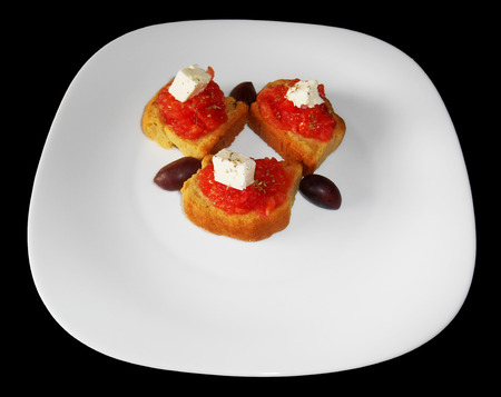 Cracker with tomato, feta cheese and olives isolatedの写真素材