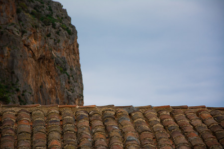 Looking at the cliff over the rooftiles at Monemvasia, Greece.の写真素材