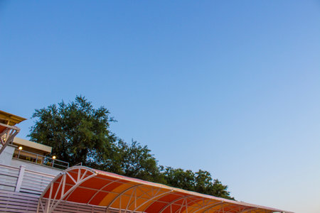 The roof of a cafe against the blue sky. View from below.