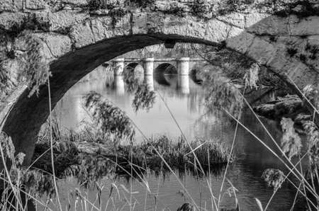 Medieval stone bridge over the Carrion River in Palencia (Castile and Leon), Spain (black and white...