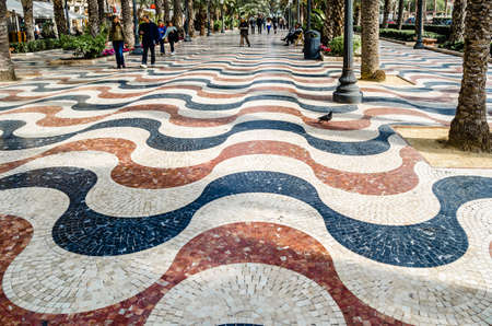 ALICANTE, SPAIN - DECEMBER 27, 2018: People walking on the Paseo de la Explanada, a promenade in the Spanish city of Alicante, one of the most popular pedestrian routes in the city.のeditorial素材