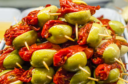 Typical Spanish olive tapas in a bar, consisting of an appetizer that is served with a drinkの写真素材