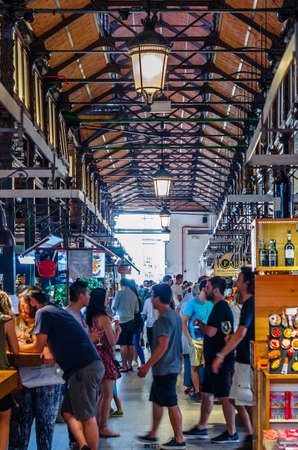 MADRID, SPAIN - AUGUST 27, 2017: People visiting and enjoying drinks and tapas inside the historical "Mercado de San Miguel" (Market of San Miguel), popular among tourists, located in the center of Madrid, Spainのeditorial素材