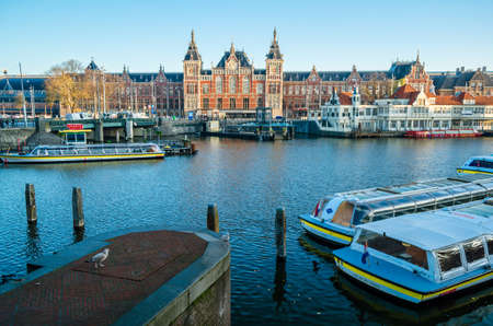 AMSTERDAM, THE NETHERLANDS - NOVEMBER 17, 2018: Boats on the canal in Amsterdam, the Netherlands