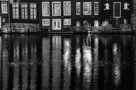 Houses along the canal and their reflection in the water in Amsterdam, the Netherlands. Black and white imageの写真素材