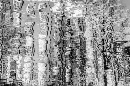 Reflection of the buildings along the canal in Amsterdam, the Netherlands. Black and white imageの写真素材