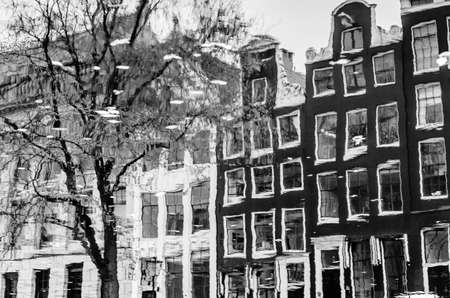 Reflection of the buildings along the canal in Amsterdam, the Netherlands. Black and white imageの写真素材