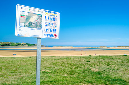 MOGRO, SPAIN - JULY 5, 2021: Covid-19 information panel on the beach showing measures to prevent infectionsのeditorial素材