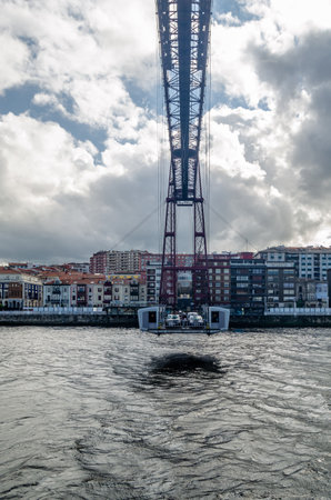 GETXO, SPAIN - JULY 7, 2021: View from Getxo, Spain: the famous Vizcaya Bridge built in 1893, declared a World Heritage Site by UNESCO and the town of Portugalete in the backgroundのeditorial素材
