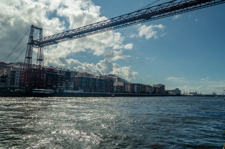 GETXO, SPAIN - JULY 7, 2021: View from Getxo, Spain: the famous Vizcaya Bridge built in 1893, declared a World Heritage Site by UNESCO and the town of Portugalete in the backgroundのeditorial素材