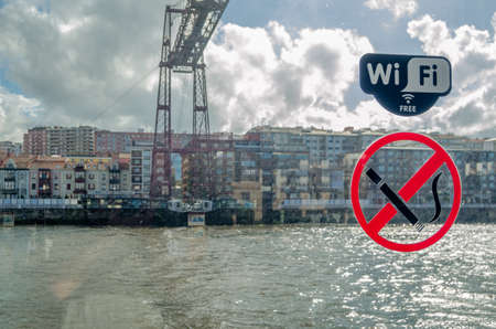 GETXO, SPAIN - JULY 7, 2021: Symbols of "free Wi-Fi" and "No smoking" in the waiting cabin to get on the transporter of the Vizcaya suspension bridgeのeditorial素材