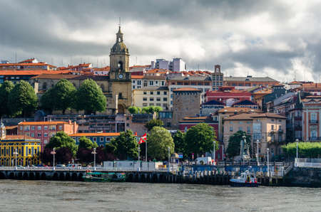 GETXO, SPAIN - JULY 7, 2021: View of the town of Portugalete on the riverside, seen from Getxo, Basque Country, Spainのeditorial素材