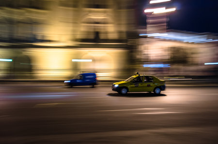 BUCHAREST, ROMANIA - NOVEMBER 17, 2013: Taxi in motion, at night in Bucharest, Romania, panning efectのeditorial素材