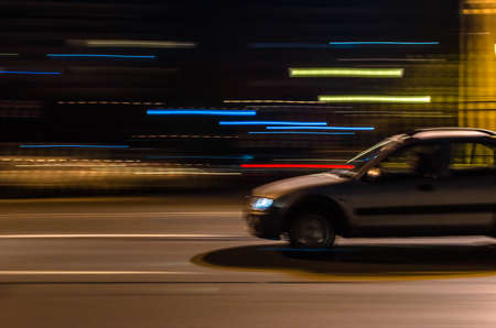 Urban night scene with car in motion using panning effectの写真素材
