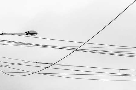Street electricity cables against gray sky backgroundの写真素材