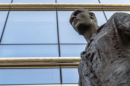 BRUSSELS, BELGIUM - AUGUST 21, 2013: Modern statue "Stepping Forward", an imposing bronze sculpture of a man walking, made by sculptor Hanneke Beaumont in 2007, located in the front of The Council of the European Union in the European Quarter of Brussels,のeditorial素材