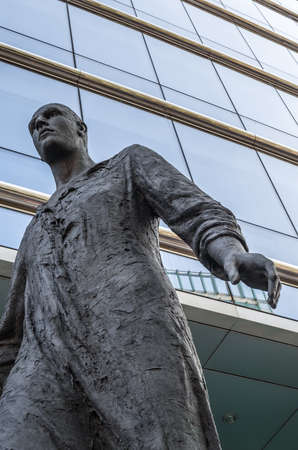 BRUSSELS, BELGIUM - AUGUST 21, 2013: Modern statue "Stepping Forward", an imposing bronze sculpture of a man walking, made by sculptor Hanneke Beaumont in 2007, located in the front of The Council of the European Union in the European Quarter of Brussels,のeditorial素材
