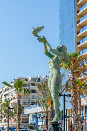 FUENGIROLA, SPAIN - OCTOBER 13, 2021: "Monumento al turista" ("Monument to the tourist") located on the seafront of Fuengirola, sculpture made in bronze, work of Andres Lopez Yebra, inaugurated in 1971のeditorial素材