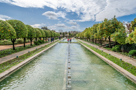 CORDOBA, SPAIN - FEBRUARY 16, 2014: People visiting the beautiful gardens of the Alcazar de los Reyes Cristianos (Spanish for "Castle of the Christian Monarchs"), a medieval fortress located in the historic center of CÃ³rdoba, Andalusia, southern Spainのeditorial素材