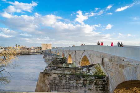 CORDOBA, SPAIN - FEBRUARY 14, 2014: People crossing the ancient Roman stone bridge of Cordoba, Andalusia, Spainのeditorial素材