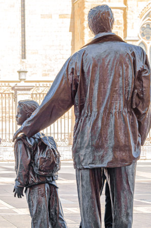 LEON, SPAIN - MARCH 9, 2014: Detail of the urban sculpture "Father and Son" ("Padre e hijo" in Spanish) made in bronze in 1997 by the artist Jesus Trapote Medina, located in front of the Leon cathedral, Spainのeditorial素材