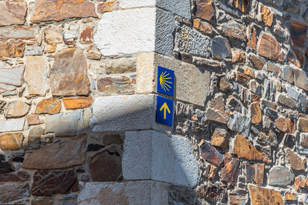 View of the Camino de Santiago symbol (arrow and yellow shell on a blue background), indicating the directions to followの写真素材