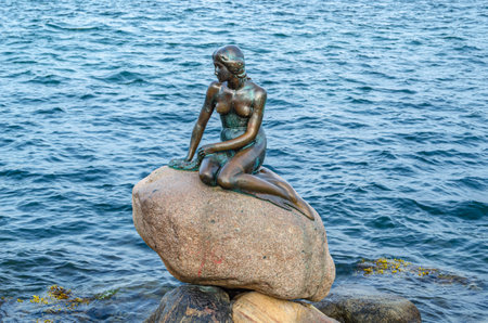 COPENHAGEN, DENMARK - JULY 8, 2014: The Little Mermaid, bronze statue by Edvard Eriksen, displayed on a rock by the waterside, is a Copenhagen icon and has been a major tourist attraction since its unveiling in 1913のeditorial素材