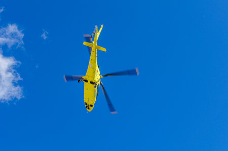 SAN LORENZO DE EL ESCORIAL, SPAIN - MARCH 23, 2014: Medical helicopter of the Medical Emergency Service of the Community of Madrid, SUMMA 112, flying after taking off from San Lorenzo de El Escorialのeditorial素材