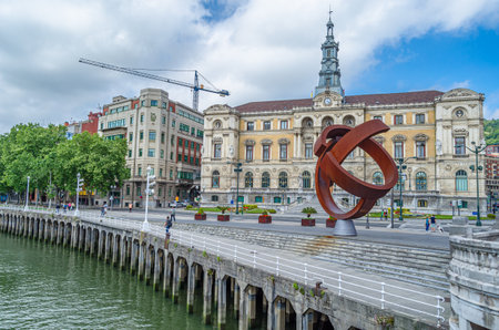 BILBAO, SPAIN - MAY 10, 2014: View of the Nervion river in Bilbao, Spain. In the background, the sculpture "Ovoid Variant", work of the Basque sculptor Jorge Oteiza, created in 1958, made of weathering steel. The work was placed in 2002 in front of the Biのeditorial素材