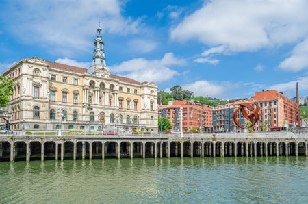 BILBAO, SPAIN - MAY 10, 2014: View of the Nervion river in Bilbao, Spain. In the background, the sculpture "Ovoid Variant", work of the Basque sculptor Jorge Oteiza, created in 1958, made of weathering steel. The work was placed in 2002 in front of the Biのeditorial素材