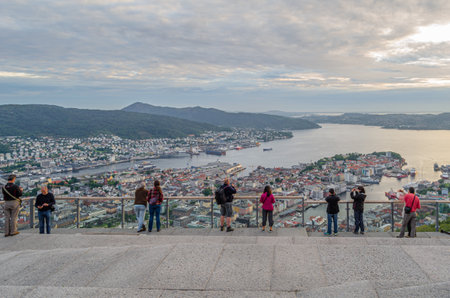 BERGEN, NORWAY - JULY 16, 2014: People at a hilltop viewpoint overlooking the old town and the harbor in the city of Bergen, Norwayのeditorial素材