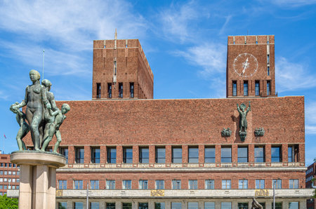 OSLO, NORWAY - JULY 12, 2014: View of the Oslo City Hall, Norway, from the statue park "Synken" on the City Hall Square, with the fountain sculpture made by Emil Lie in the foregroundのeditorial素材
