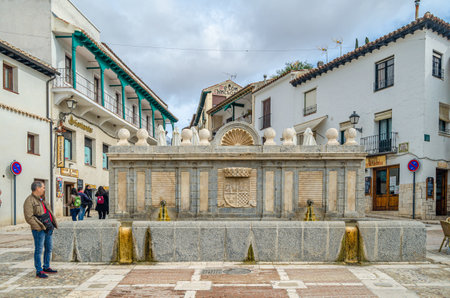 CHINCHON, SPAIN - NOVEMBER 2, 2019: Fuente de Arriba, a wall fountain in the main square (Plaza Mayor) of Chinchon, Spain, is a recent construction (1966), but perfectly integrated into the medieval square. It replaced a primitive structure, of uncertain のeditorial素材