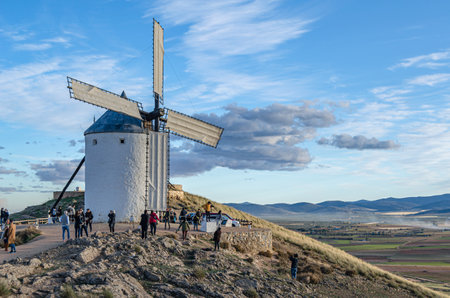 CONSUEGRA, SPAIN - NOVEMBER 16, 2019: Tourists visiting the typical windmills in the village of...