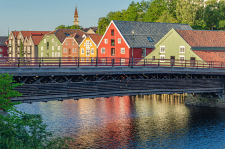 View of old wooden storehouses flanking both sides of the Nidelva river in the old town of Trondheim, Norwayの写真素材