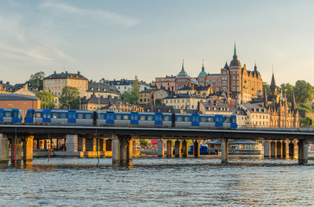 STOCKHOLM, SWEDEN - JULY 26, 2014: Subway train (metrotrain) which is part of Stockholm metro, crossing a bridge in the old town of Stockholm, Swedenのeditorial素材