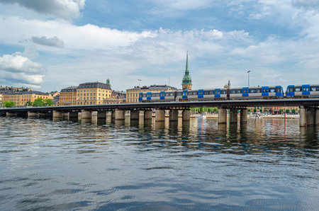 STOCKHOLM, SWEDEN - JULY 27, 2014: Subway train (metrotrain) which is part of Stockholm metro, crossing a bridge in the old town of Stockholm, Swedenのeditorial素材
