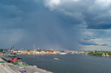 STOCKHOLM, SWEDEN - JULY 27, 2014: Urban scene in Stockholm, Sweden, view of buildings at the waterfront with storm clouds in the backgroundのeditorial素材