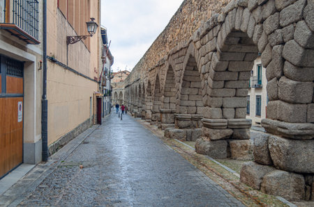 SEGOVIA, SPAIN - DECEMBER 22, 2019: Tourists visiting the famous Roman aqueduct, landmark of Segovia, Castile and Leon, Spainのeditorial素材